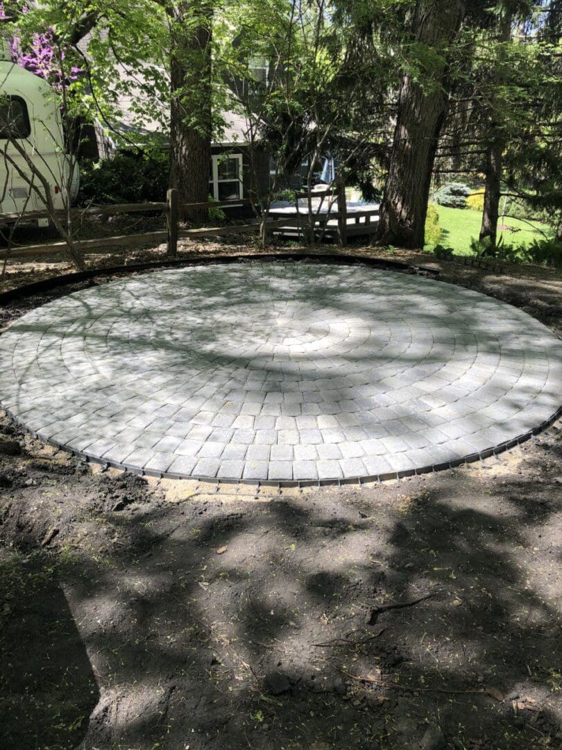 A circular patio in the middle of a yard.