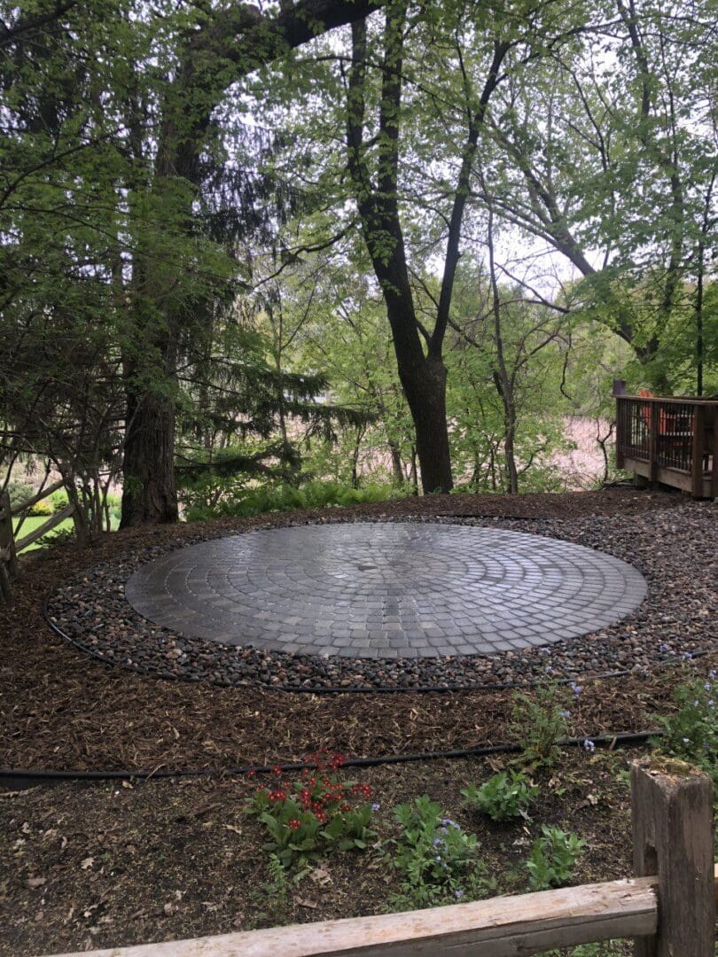 A circular stone patio in the middle of a forest.