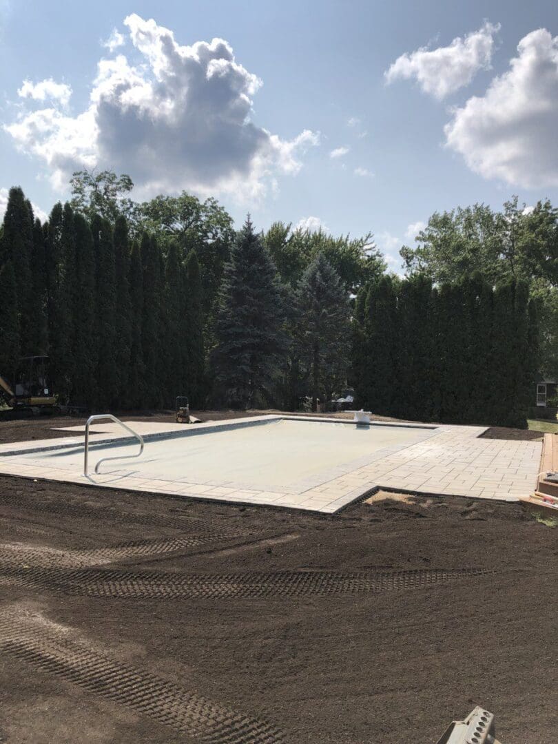A pool that is being built in the middle of a yard.